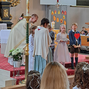 Die Kinder bringen die Utensilien für die Hl. Kommunion
